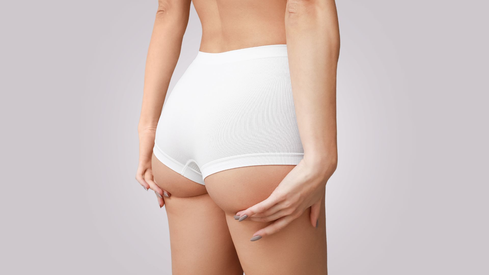 A woman facing away from the camera wearing white shorts