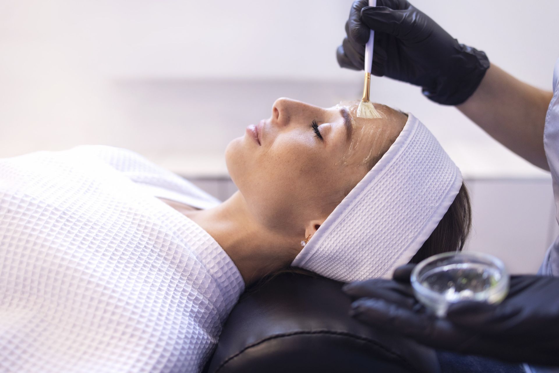 A woman is getting a facial treatment at a beauty salon.