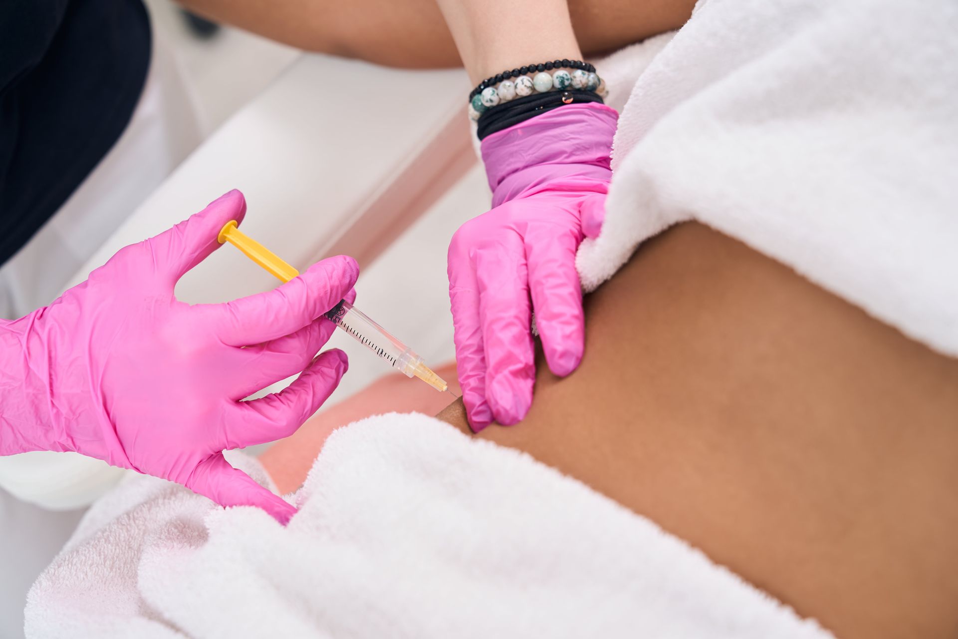 A medical provider injecting a client's stomach