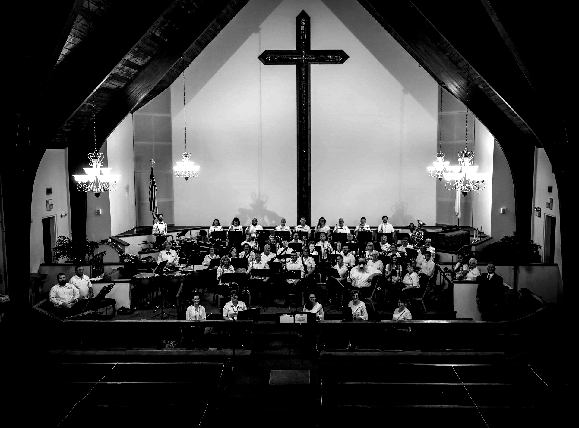 Church band playing in front of a large cross. Black and white photo.