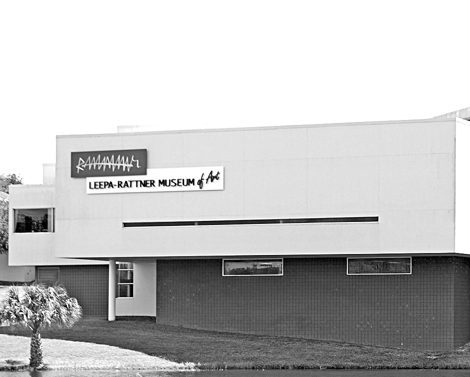 Black and white photo of the Leepa-Rattner Museum of Art. The building is two stories with a white exterior and a red brick base.