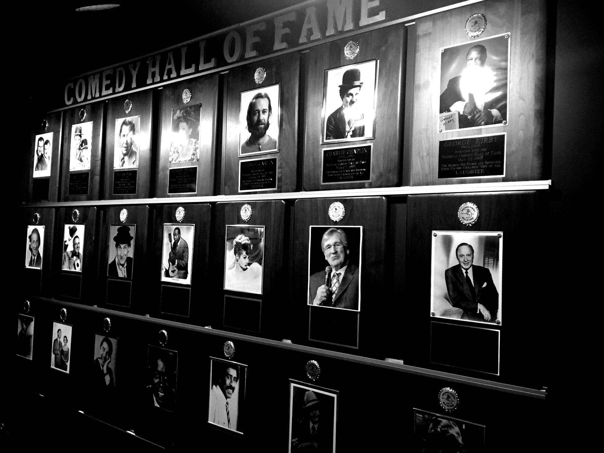 Comedy Hall of Fame plaques with black and white portraits of comedians.