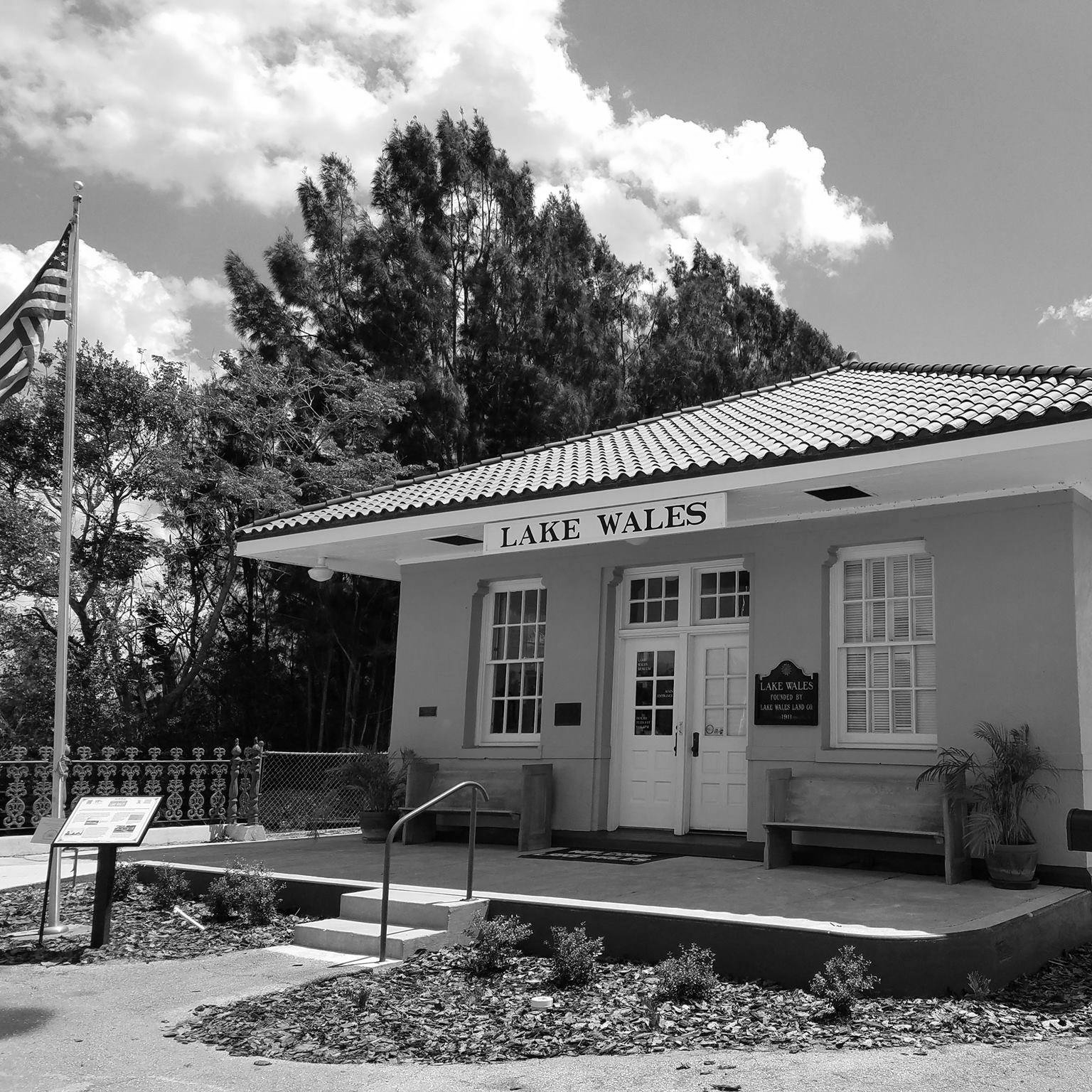 Lake Wales, Florida train depot with American flag and cloudy sky.