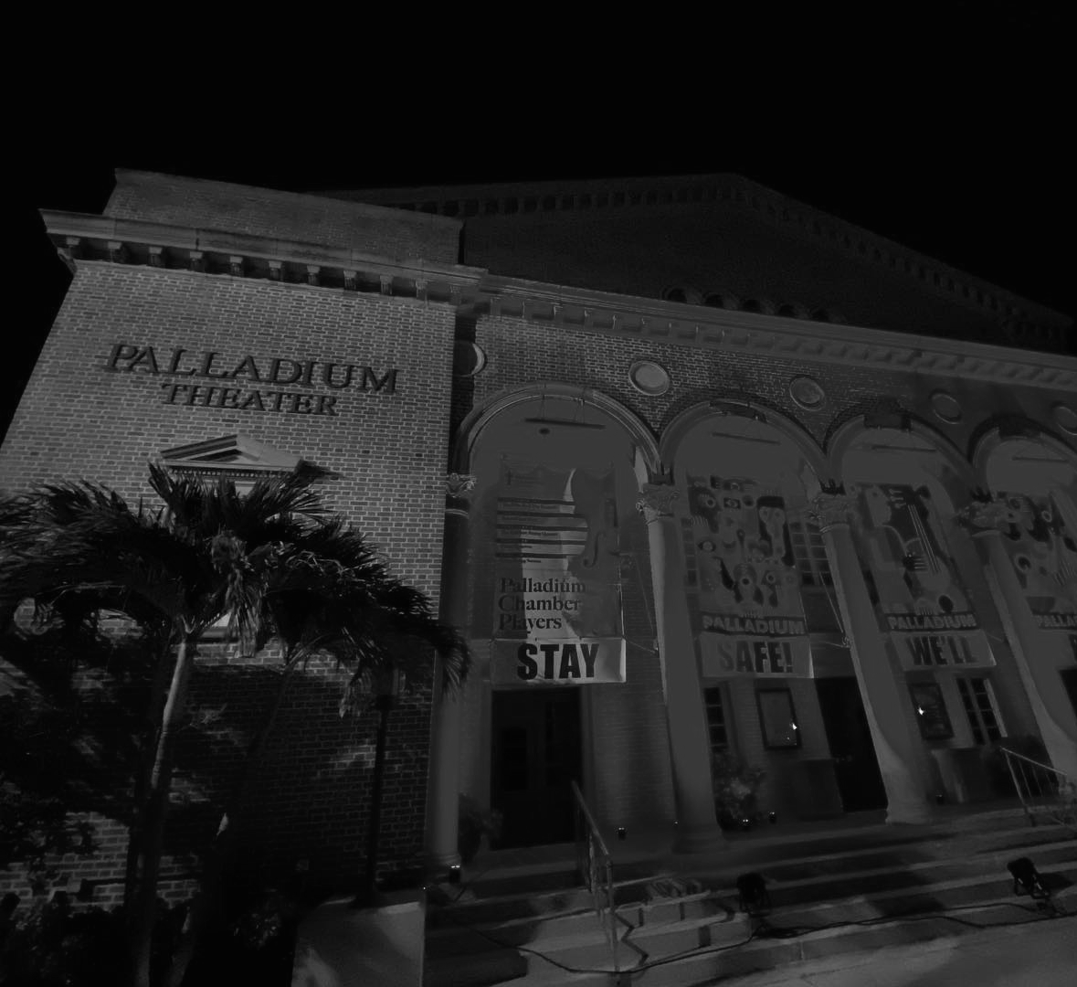Palladium Theater at night. Black and white photo. Palm tree in front.