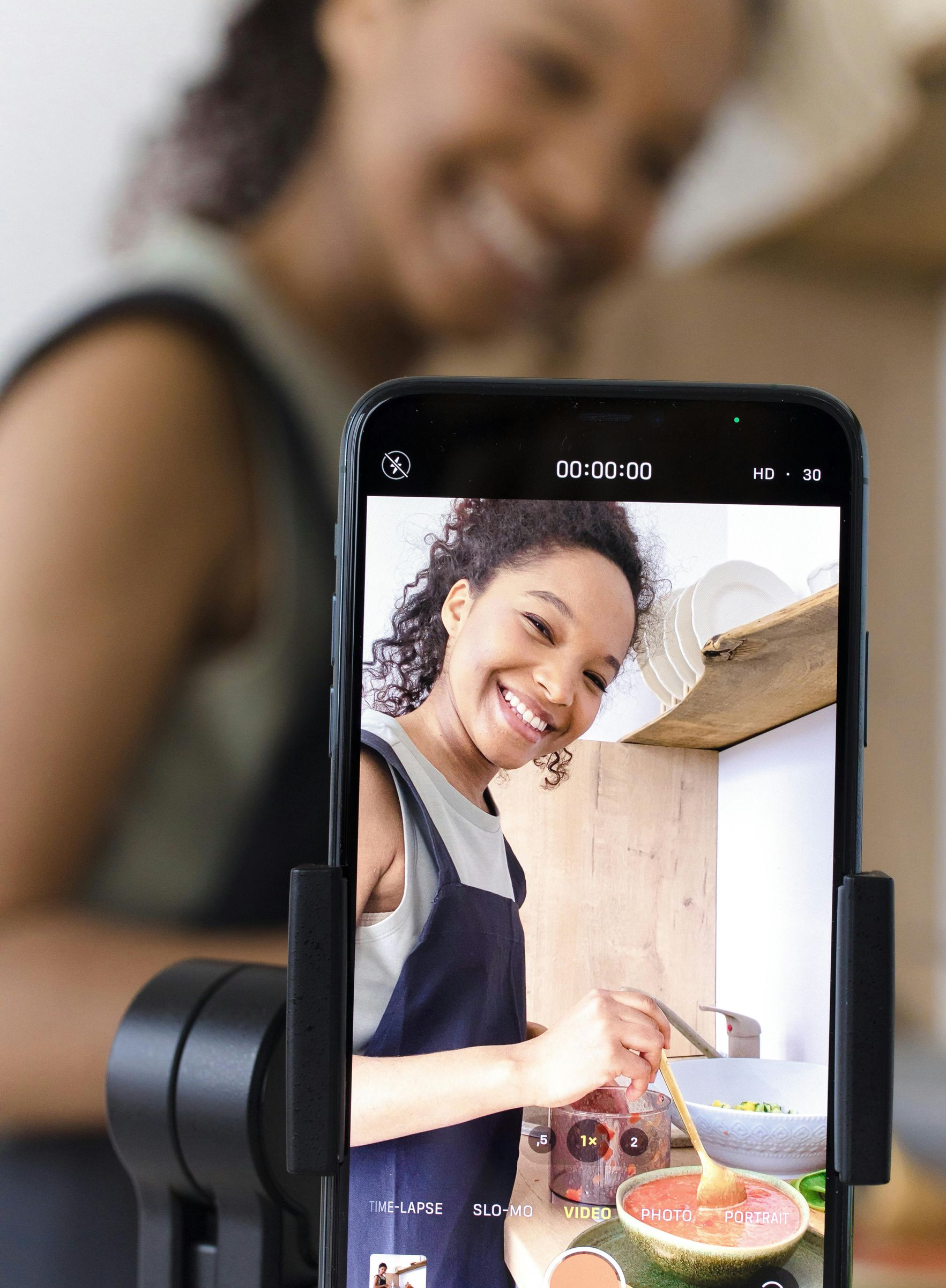 Graffiti-covered tunnel leads to a cityscape with a high-rise building under a cloudy sky.