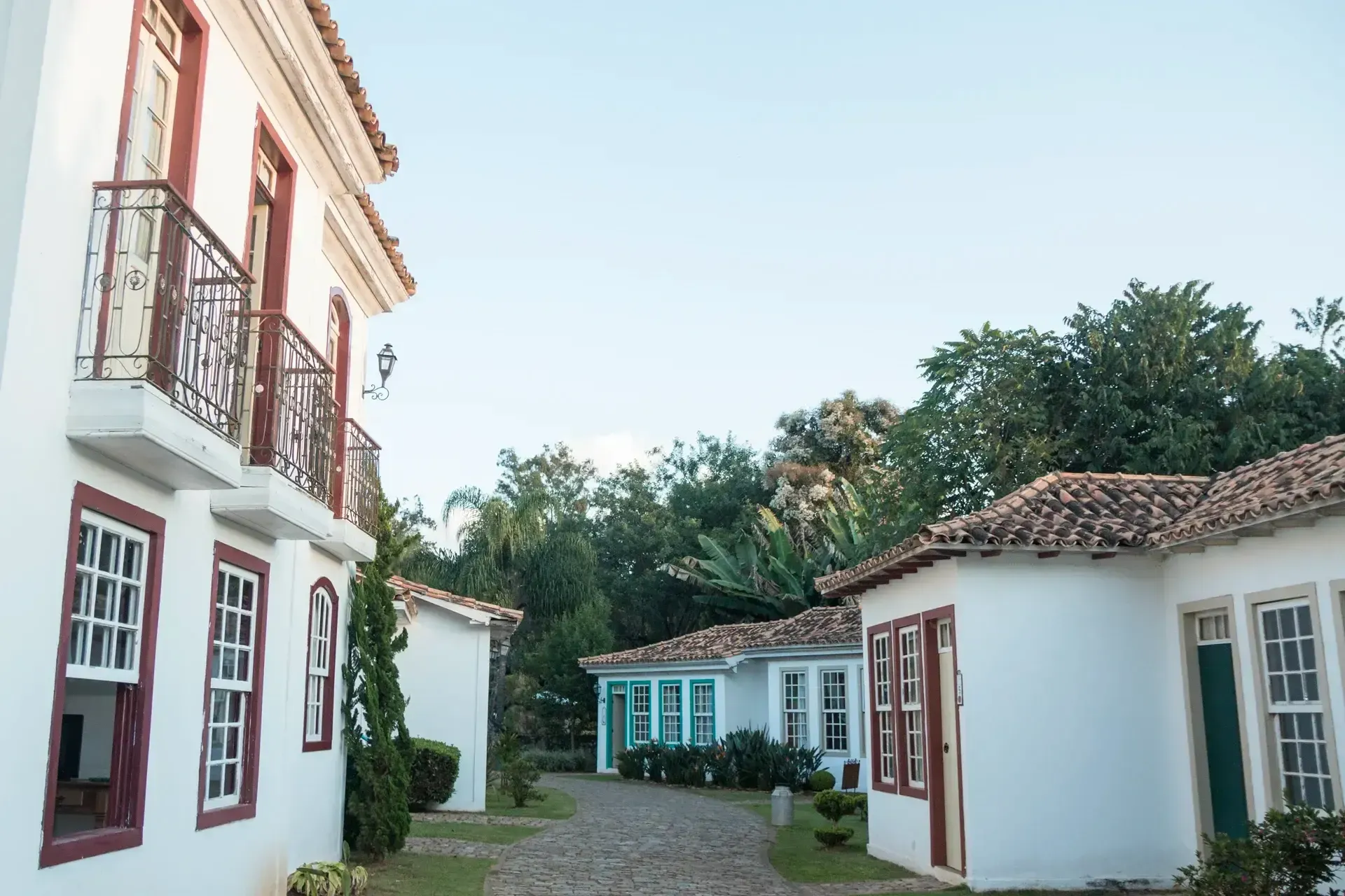 Uma fileira de casas brancas com detalhes vermelhos e varandas