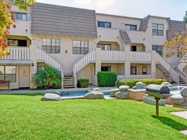 A large apartment building with a swimming pool in front of it.