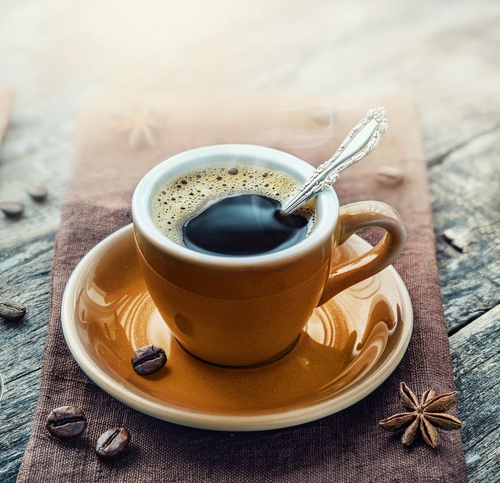 A cup of coffee with a spoon in it on a saucer