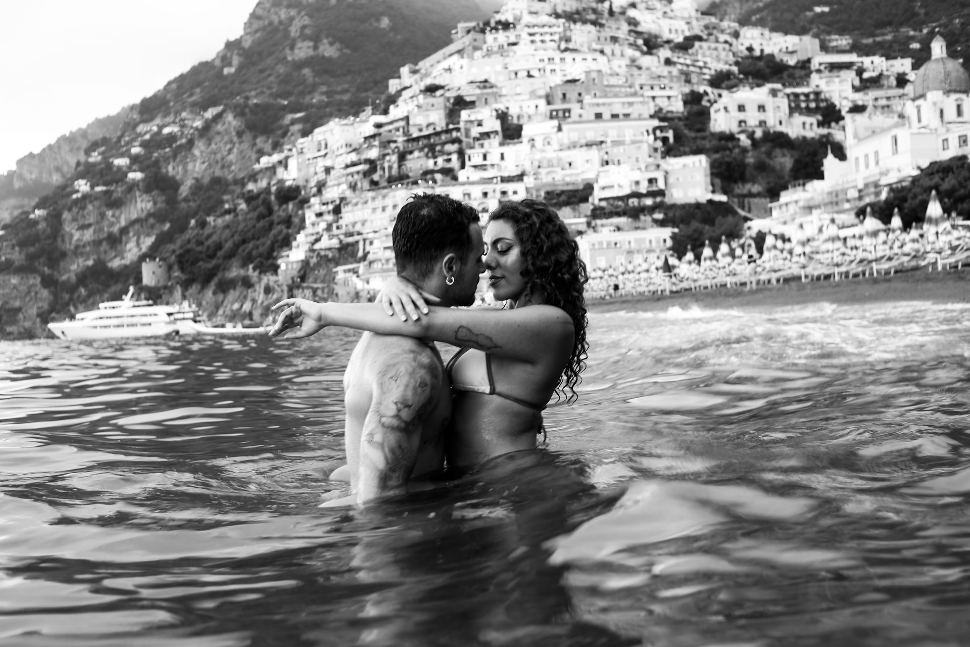Couple kissing in the water in Positano – Romantic Sunset Photo.