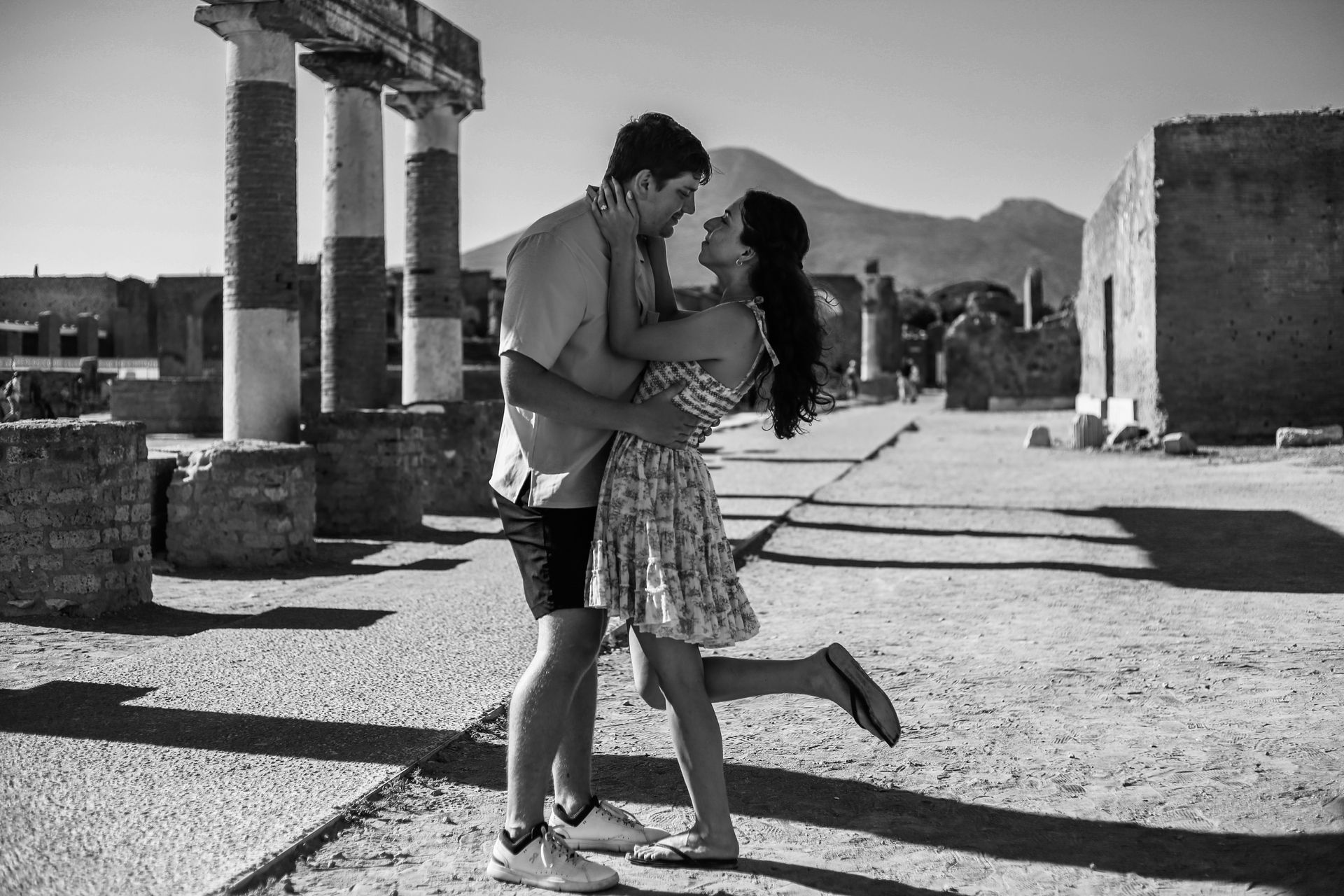 Couple kissing between the columns of Pompeii – Historic Photography Session.