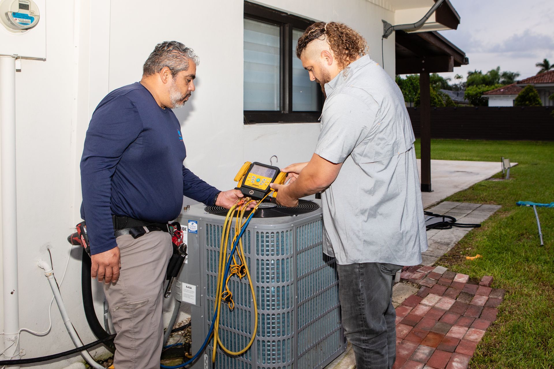 A blue umbrella is sitting next to an air conditioner.
