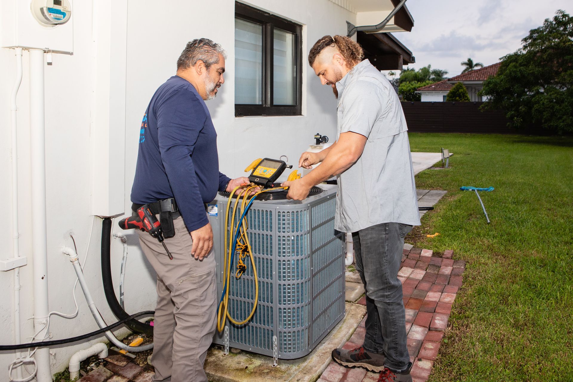 A man wearing a mask is working on an air conditioner.