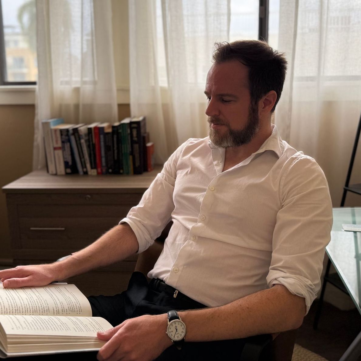 A woman is holding another woman 's hand while sitting down.