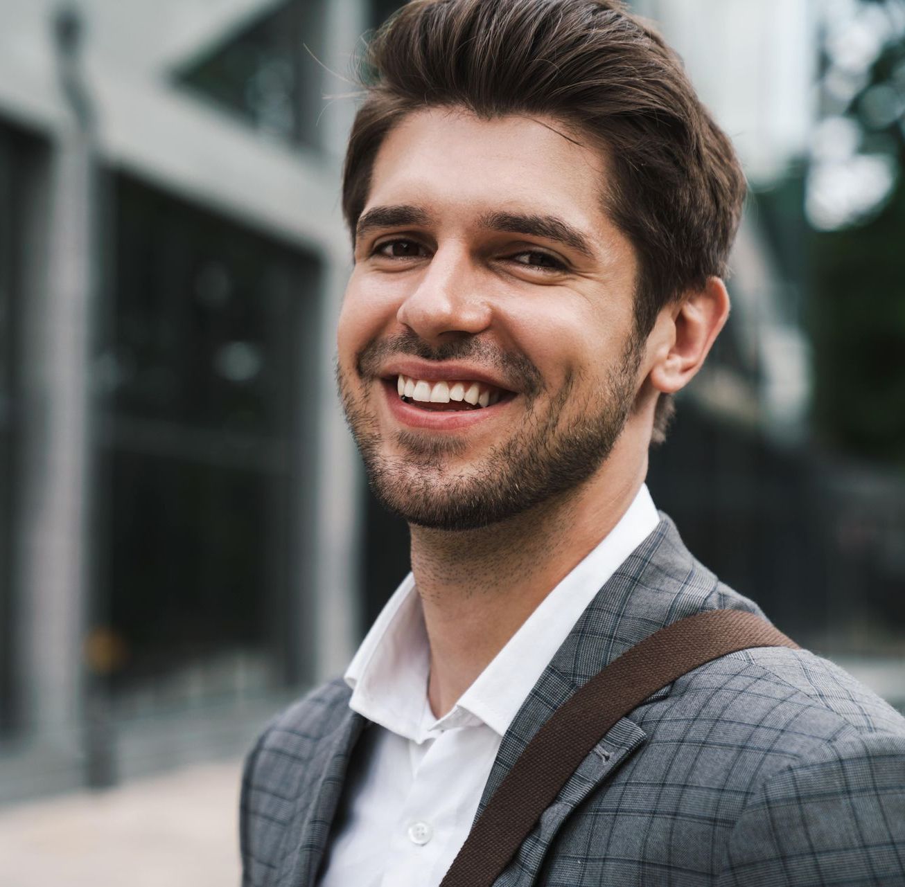 A man in a suit and white shirt is smiling for the camera