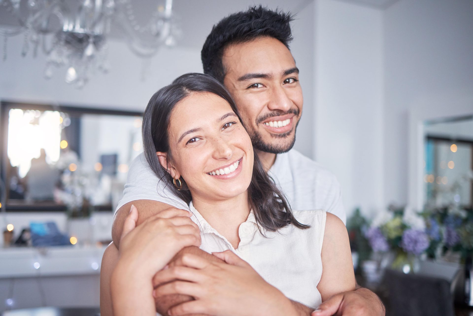 A man is hugging a woman in a living room.