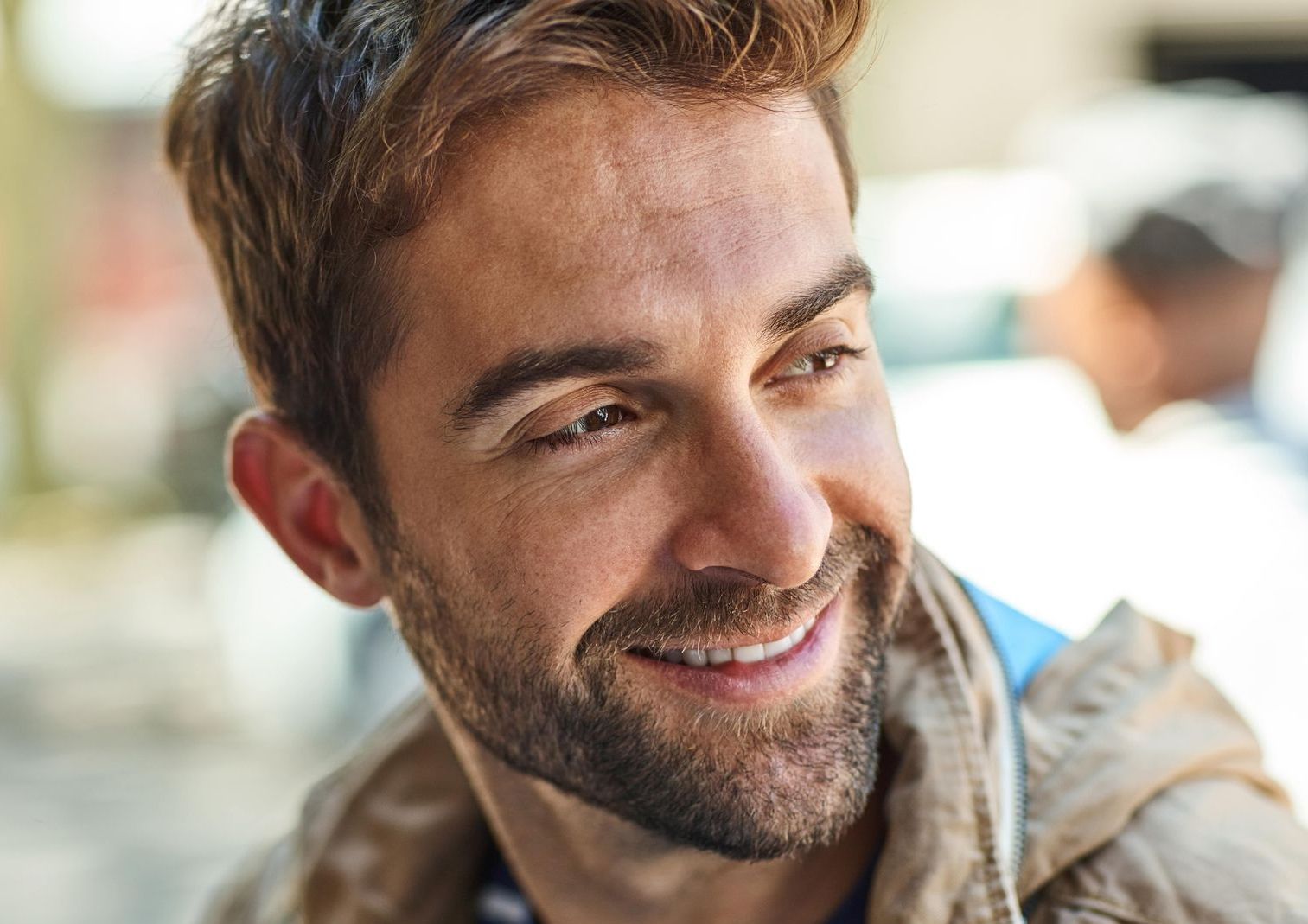 A close up of a man with a beard smiling.