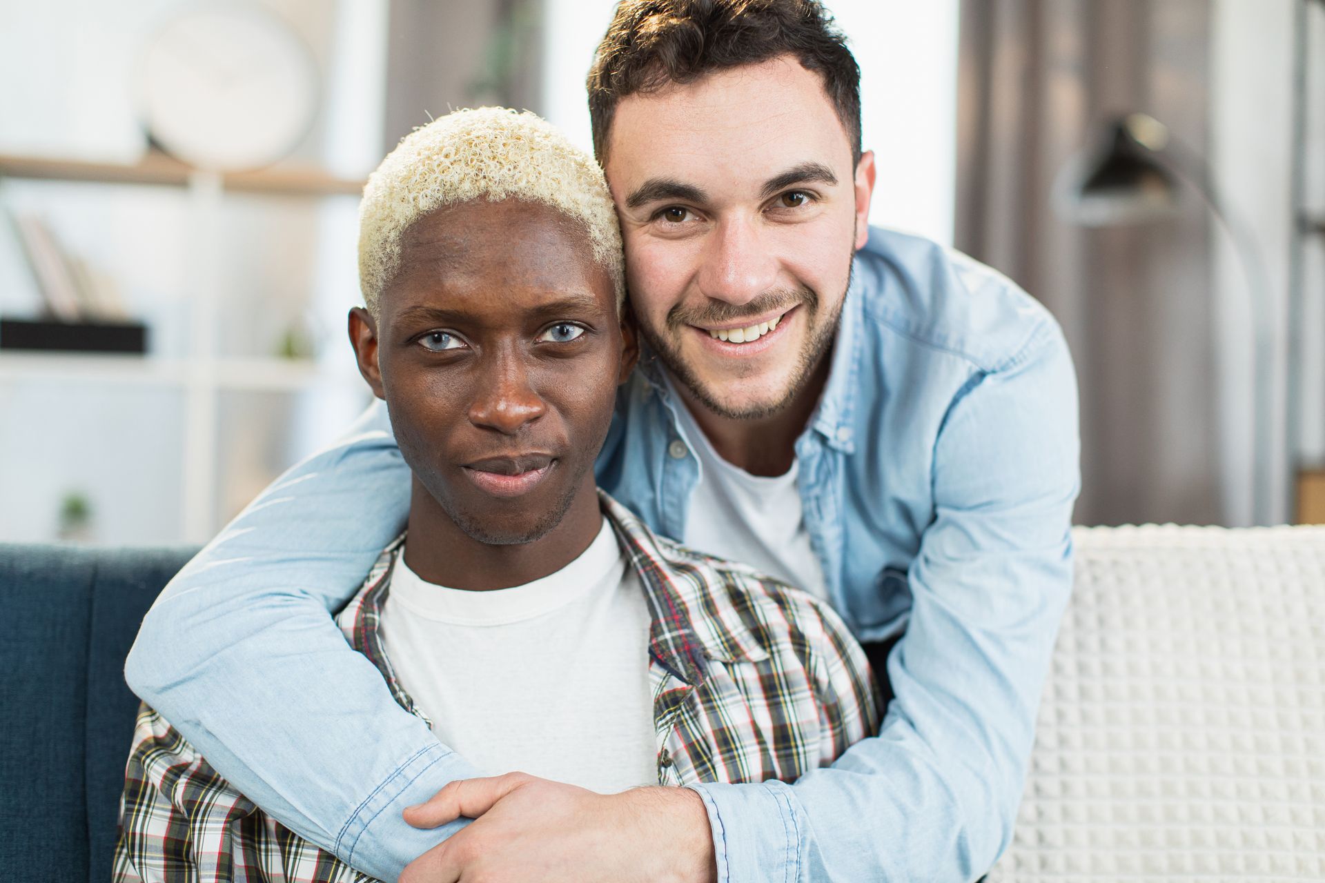 A man and a woman are taking a selfie together in a park.