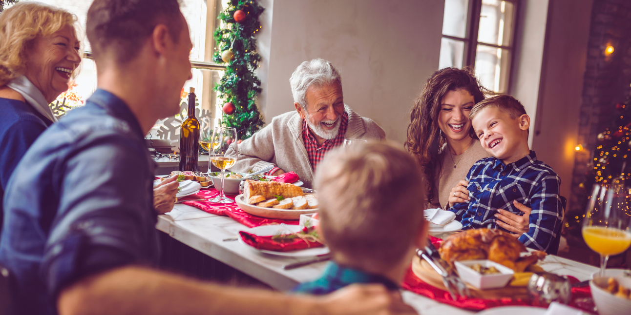 A family is sitting at a table eating christmas dinner.