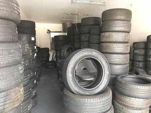 A Warehouse Filled with Lots of Tires Stacked on Top of Each Other — Budget Tyre Shed In Charmhaven, NSW