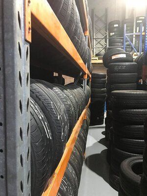 A Warehouse Filled with Lots of Tires Stacked on shelves — Budget Tyre Shed In Charmhaven, NSW
