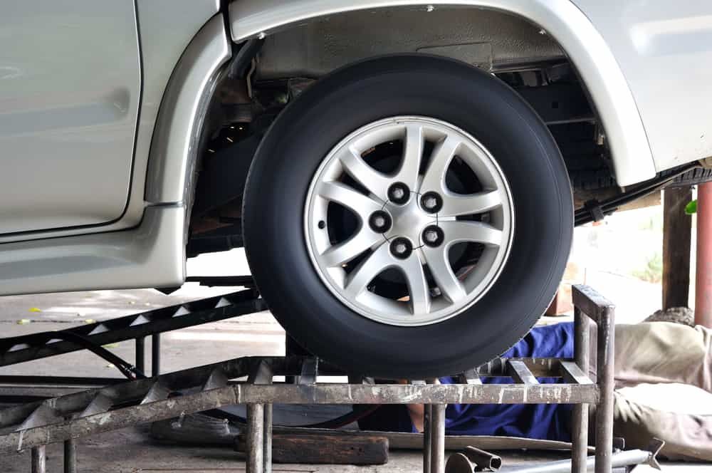 A Car Is Sitting on Top of A Metal Ramp in A Garage — Budget Tyre Shed In Charmhaven, NSW