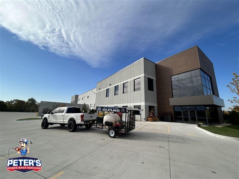 Image of a commercial building cleaned by Peter's Power Wash Service. You can see a two stroy building with a large parking lot that has been pressure and soft washed. 