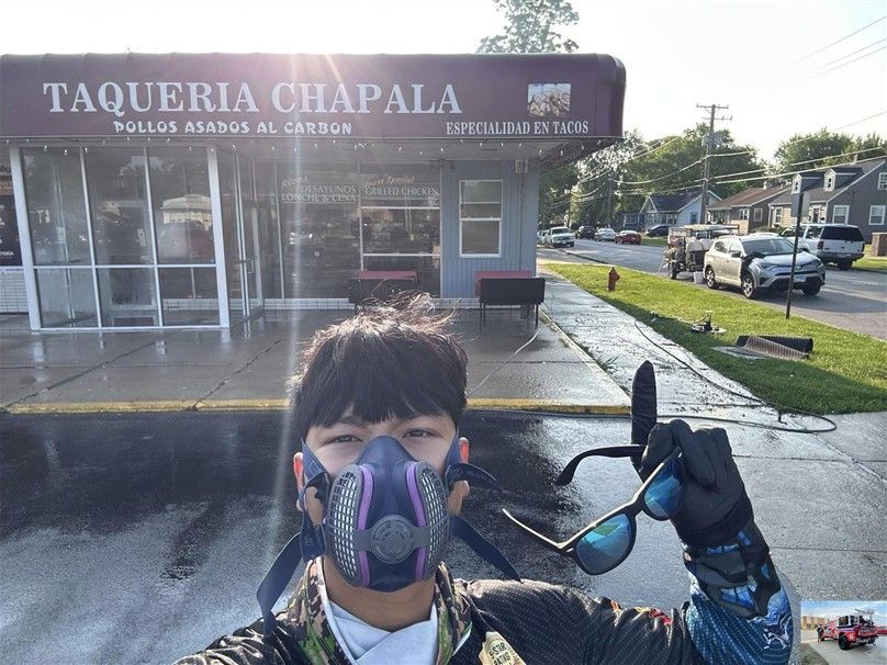 Image of the owner of Peter's Power Wash Services standing in front of a building that was power washed.