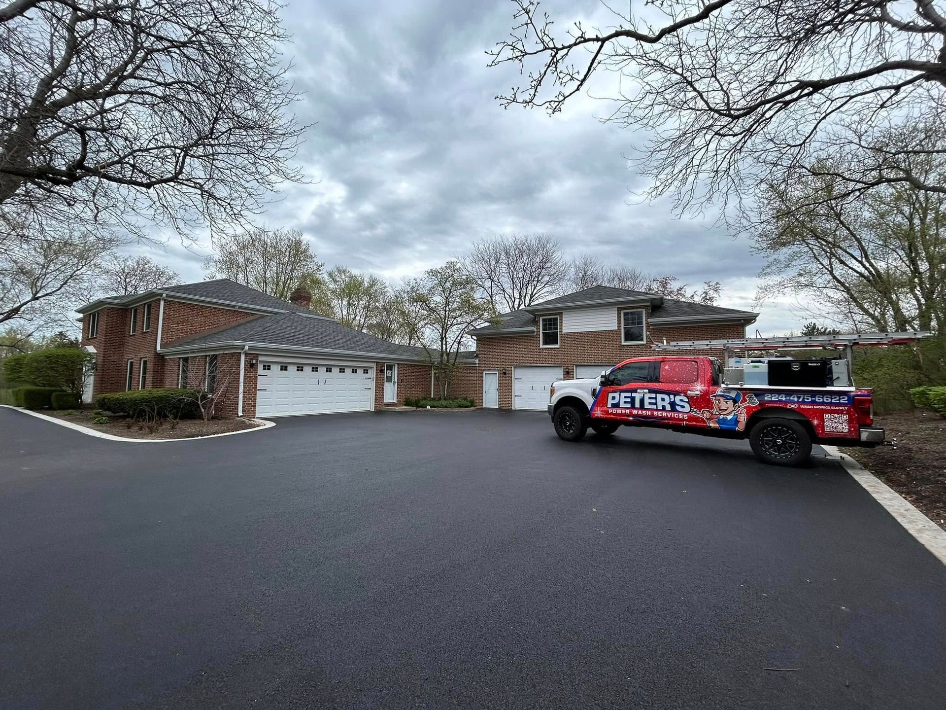 Image of a commercial building cleaned by Peter's Power Wash Service. You can see a two stroy building with a large parking lot that has been pressure and soft washed. 