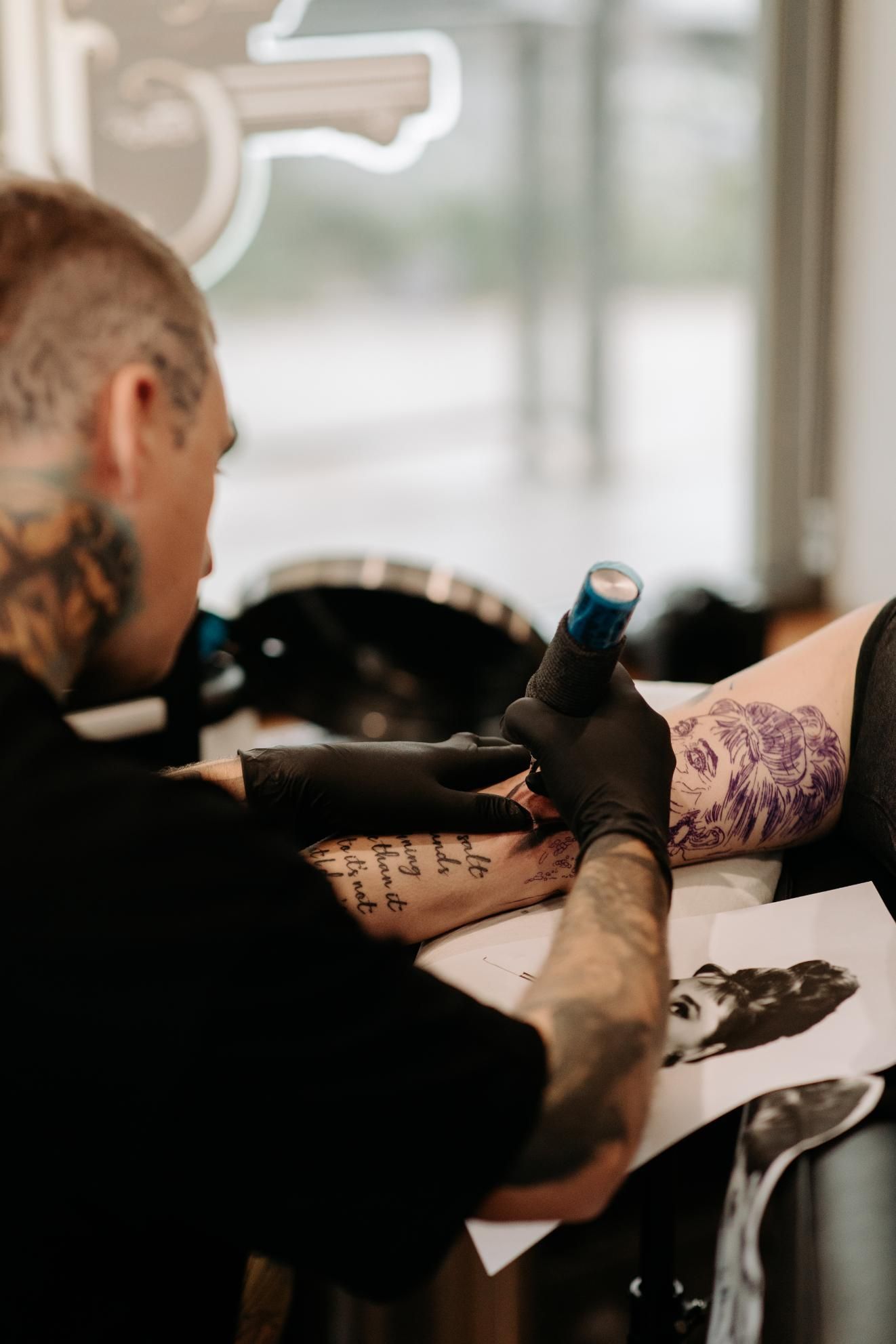 A Man is Getting a Tattoo on a Woman 's Arm — Gallery Tattoo in Medowie, NSW