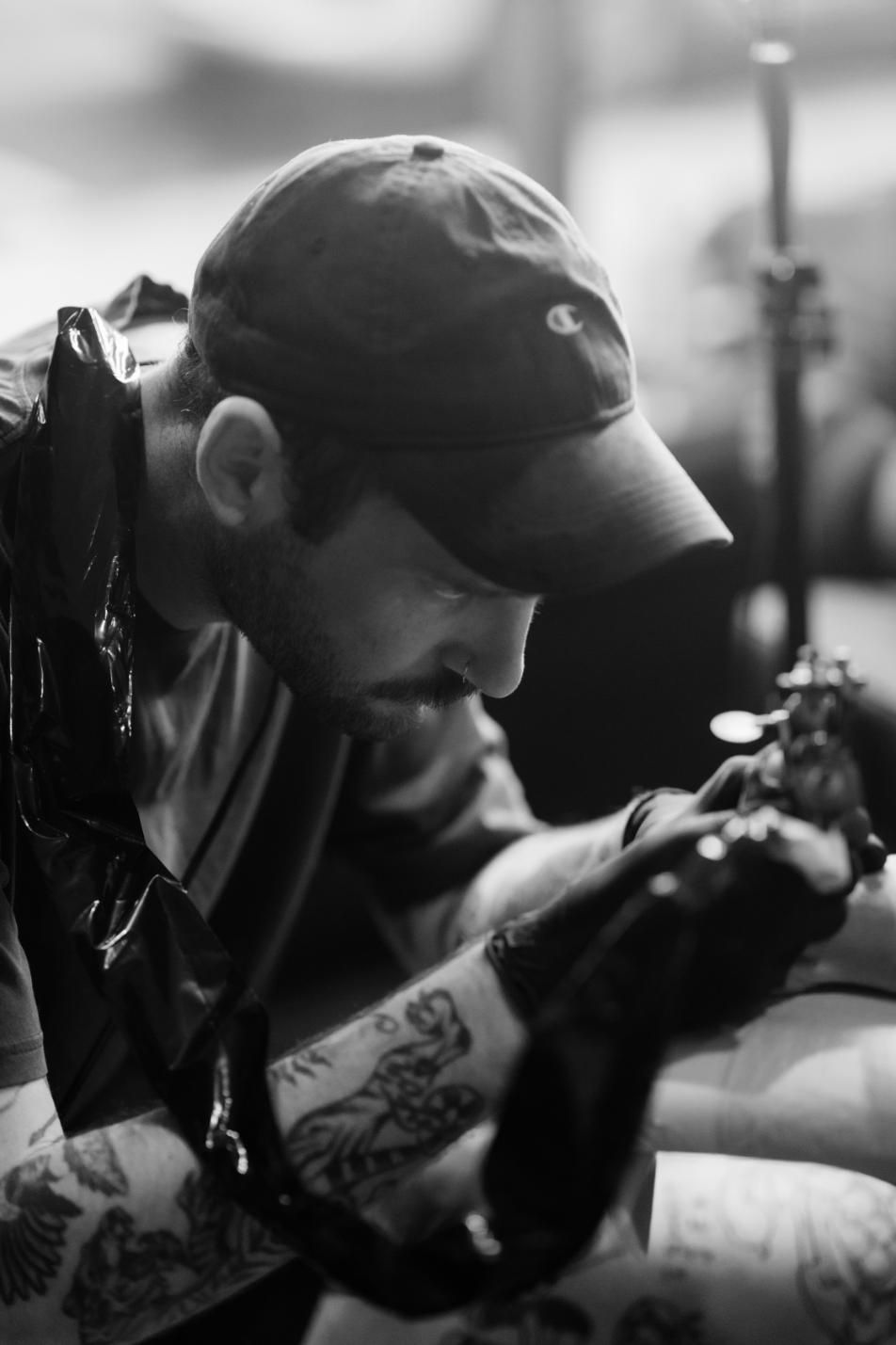 A Man is Getting a Tattoo on Another Man 's Arm — Gallery Tattoo in Maitland, NSW