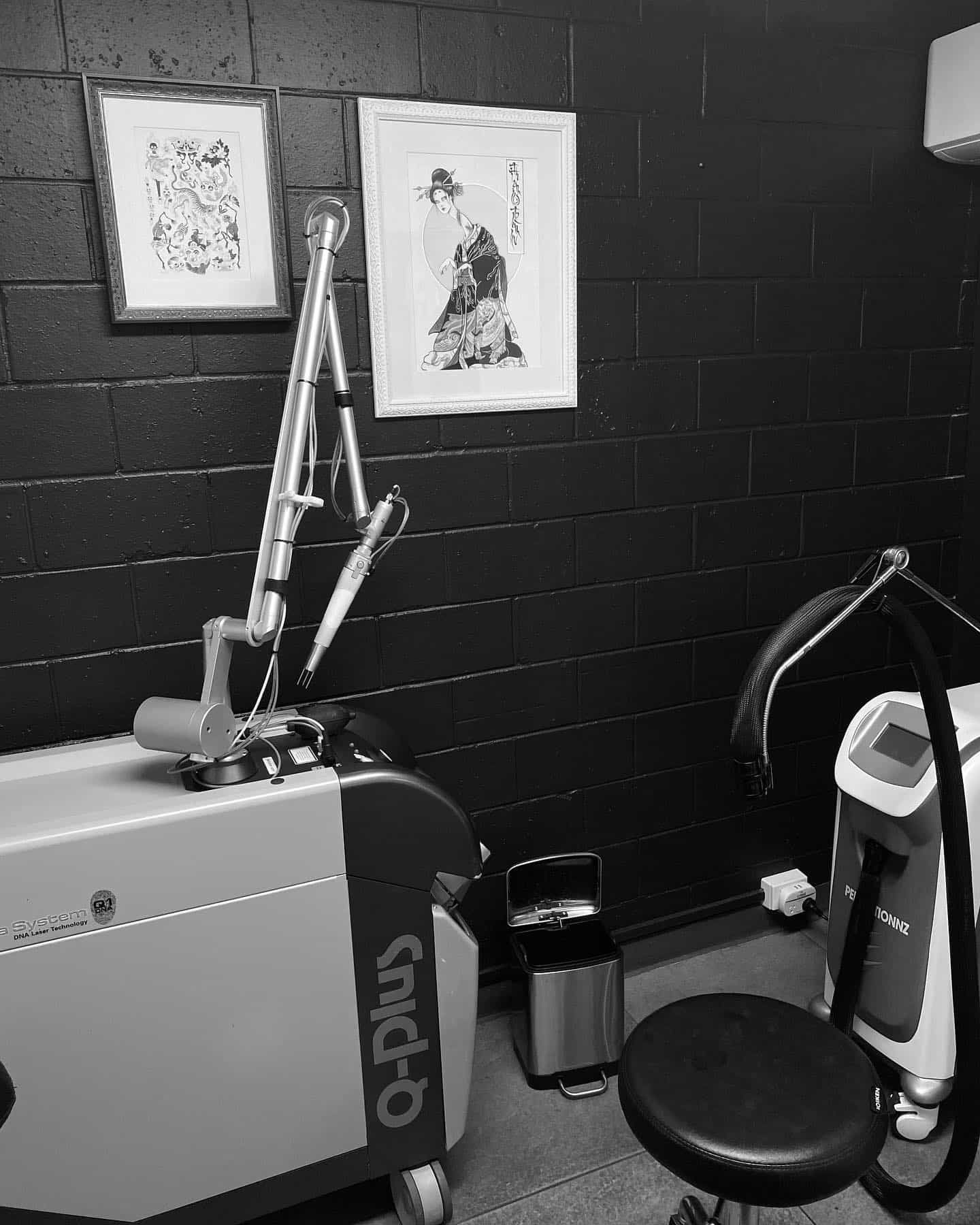 A Black and White Photo of a Room With a Machine and a Chair — Gallery Tattoo in Newcastle, NSW