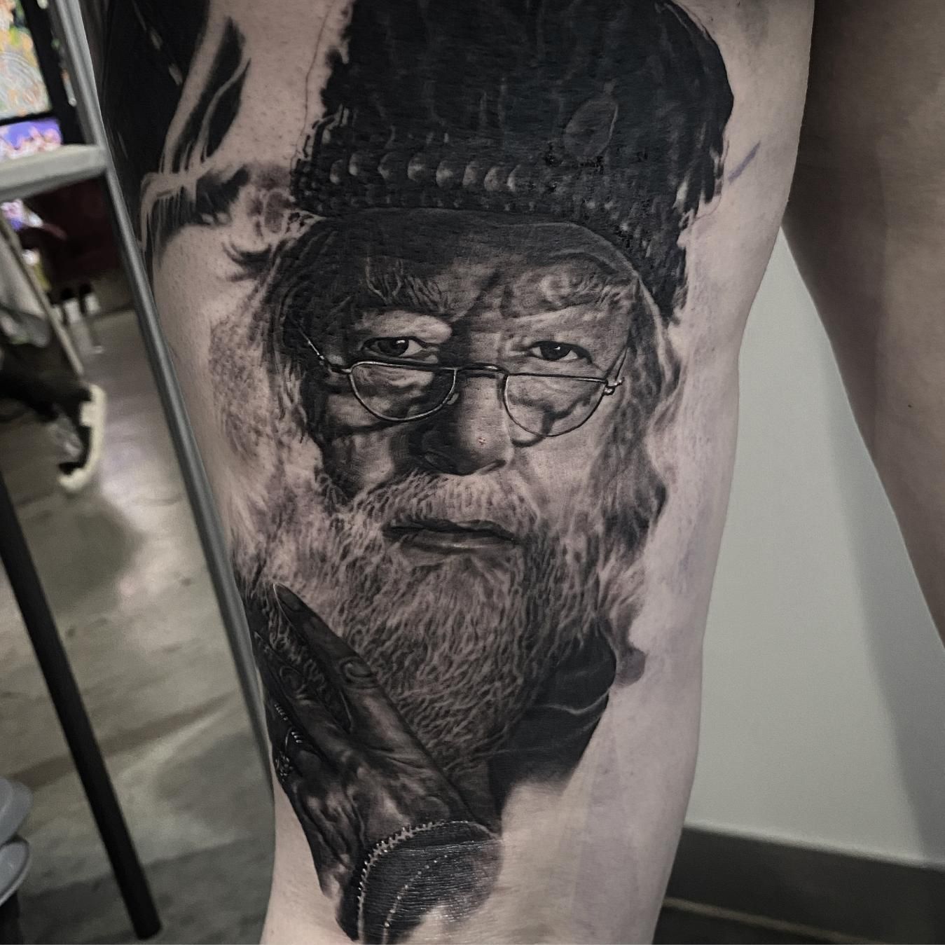 A Black and White Tattoo of a Man With a Beard and Glasses on His Leg — Gallery Tattoo in Medowie, NSW
