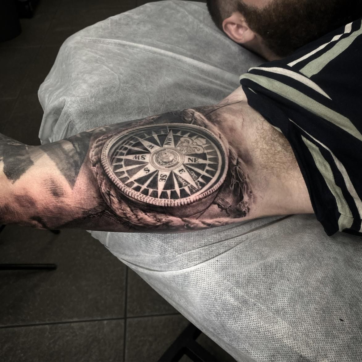 A Man Has a Tattoo of a Compass on His Arm — Gallery Tattoo in Medowie, NSW
