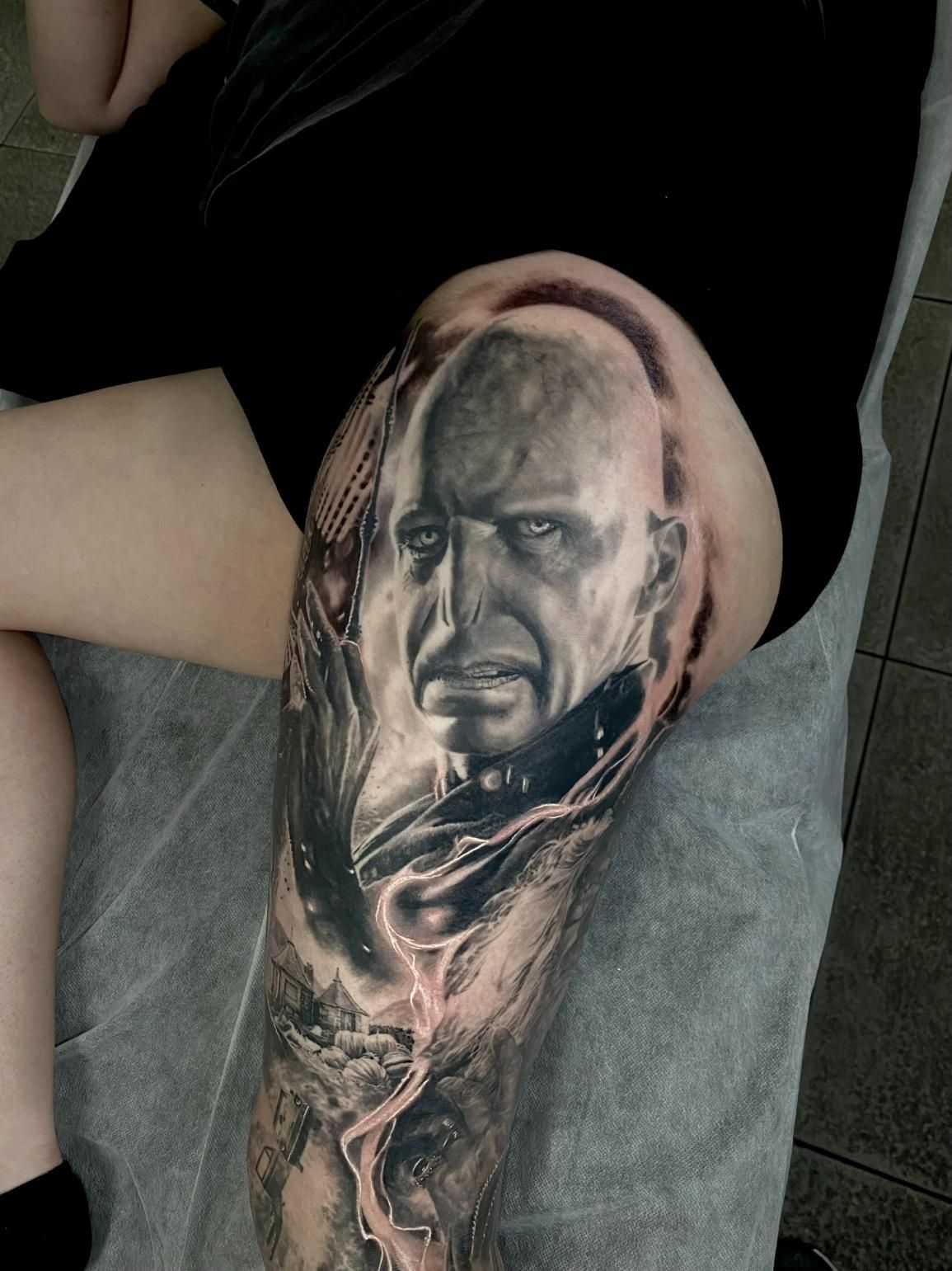 A Woman Has a Tattoo of a Bald Man on Her Leg — Gallery Tattoo in Medowie, NSW