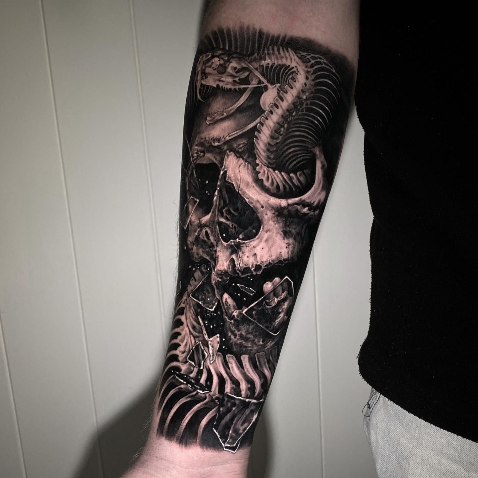 A Man Has a Tattoo of a Skull and Snake on His Forearm — Gallery Tattoo in Medowie, NSW