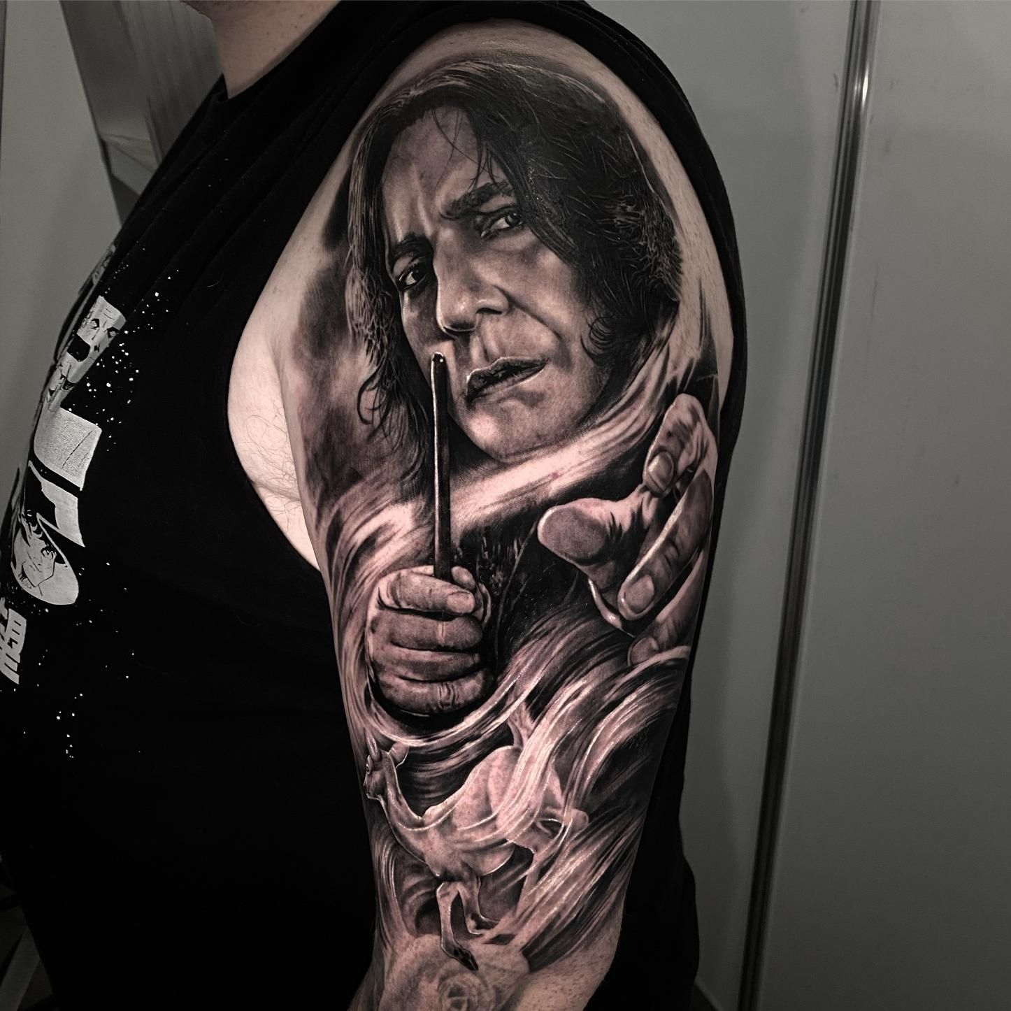 A Man Has a Tattoo of a Man Holding a Wand on His Arm — Gallery Tattoo in Medowie, NSW