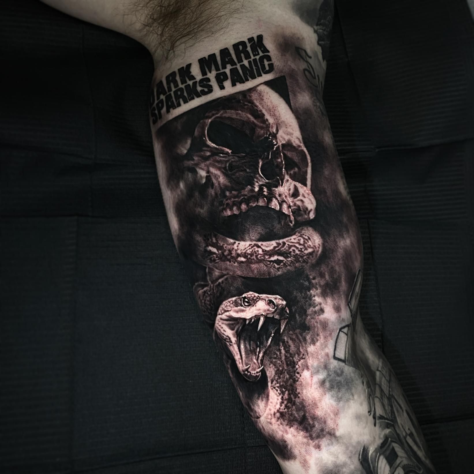 A Black and White Tattoo of a Skull and Snake on a Man 's Arm — Gallery Tattoo in Medowie, NSW