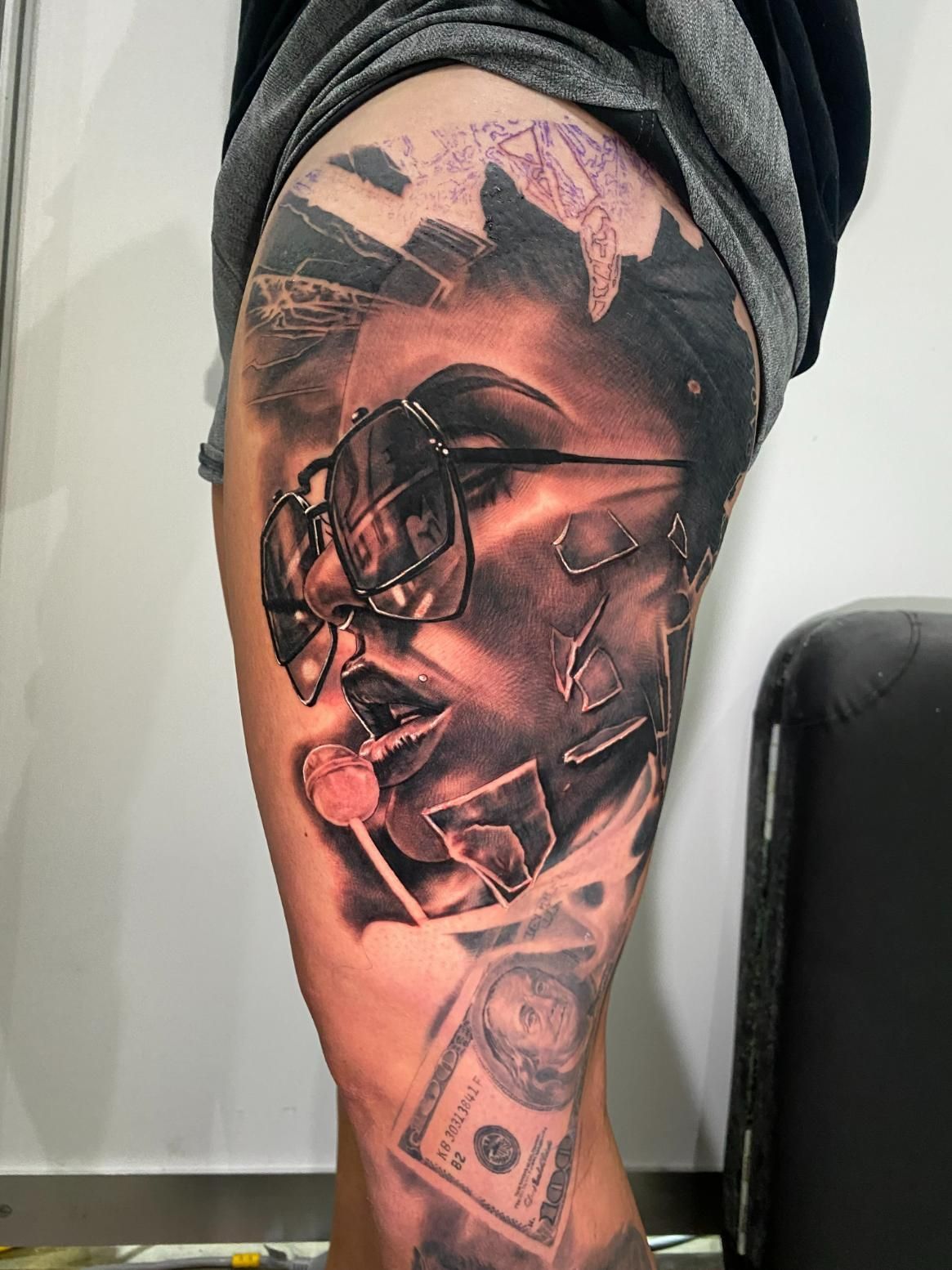 A Man Has a Tattoo of a Woman Holding a Lollipop and a Dollar Bill on His Leg — Gallery Tattoo in Medowie, NSW