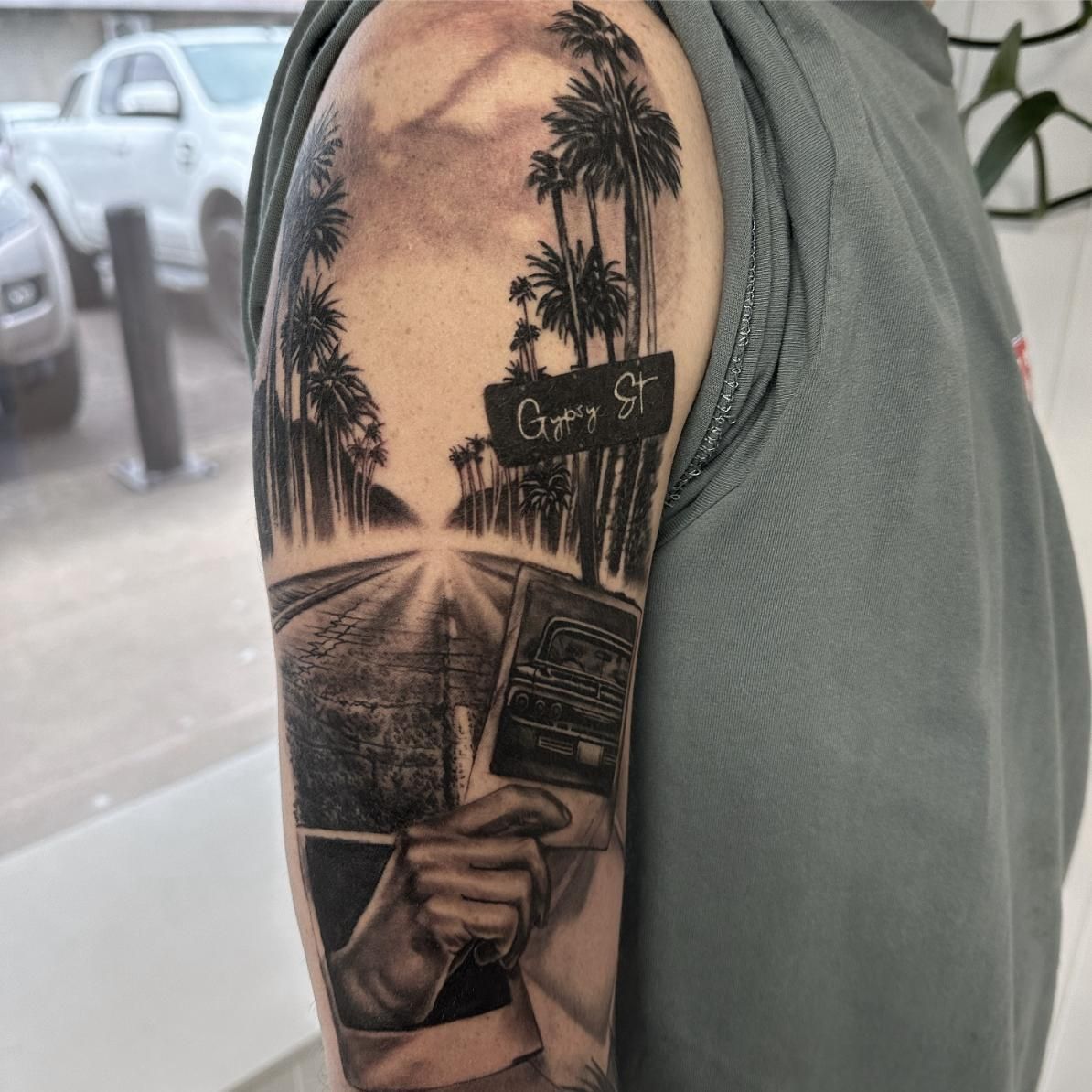 A Man Has a Tattoo on His Arm of a Road and Palm Trees — Gallery Tattoo in Medowie, NSW