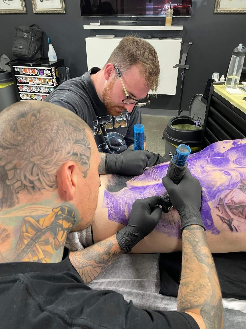 Two Men Are Getting a Tattoo on a Person 's Leg — Gallery Tattoo in Medowie, NSW