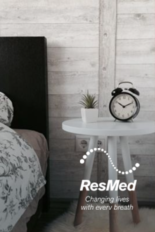 Bedroom scene with ResMed logo, small white table, alarm clock, and plant.