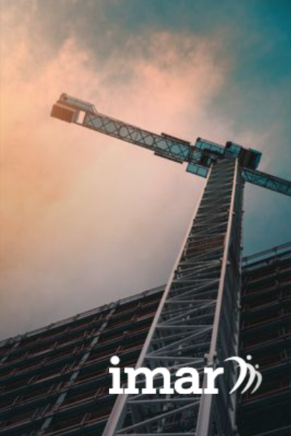 Construction crane against a cloudy sky with building, 