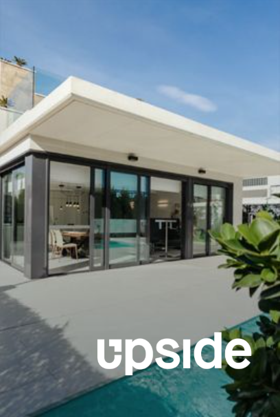 Modern building with glass doors overlooking a pool; 