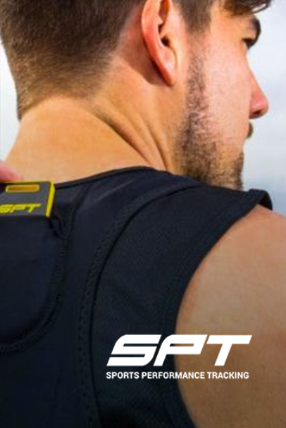 Man wearing a black vest with a yellow rectangle, SPT logo, blurred outdoor setting.