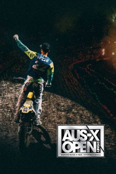 Motorcycle rider celebrates victory on the track, arm raised. 