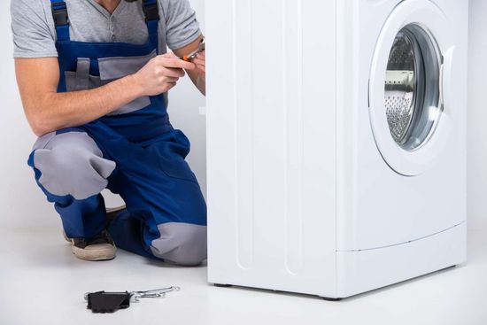 Repairman is repairing a washing machine