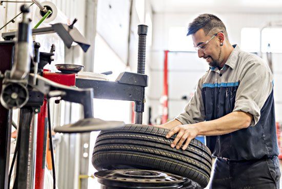 Mechanic Replacing the Car Tire — Elmira, NY — Steve's American Lifetime Muffler