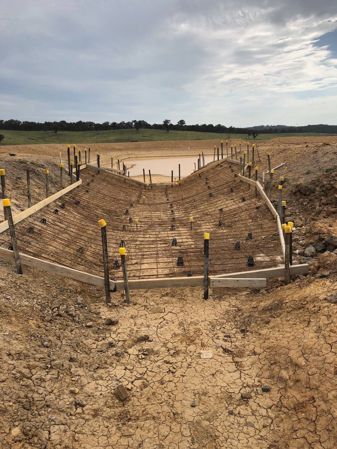 Construction Site With Earthen Berms and Stakes — Heritage Concrete In Uralla, NSW