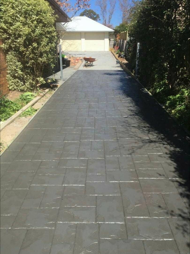 Dark Gray Stamped Concrete Driveway Leading to a Garage — Heritage Concrete In Uralla, NSW