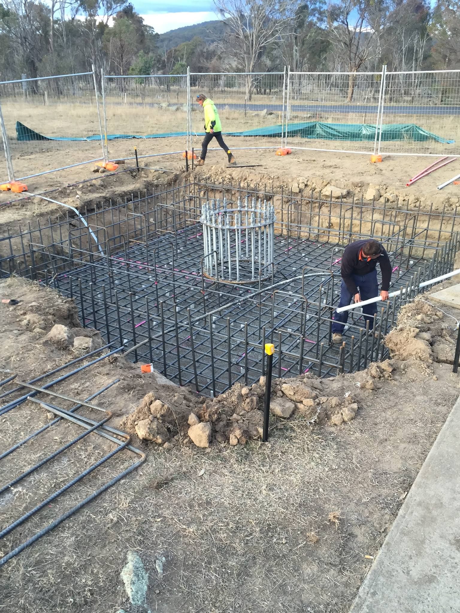 Construction Site With Workers, Rebar Framework, and a Cylindrical Cage — Heritage Concrete In Bendemeer, NSW